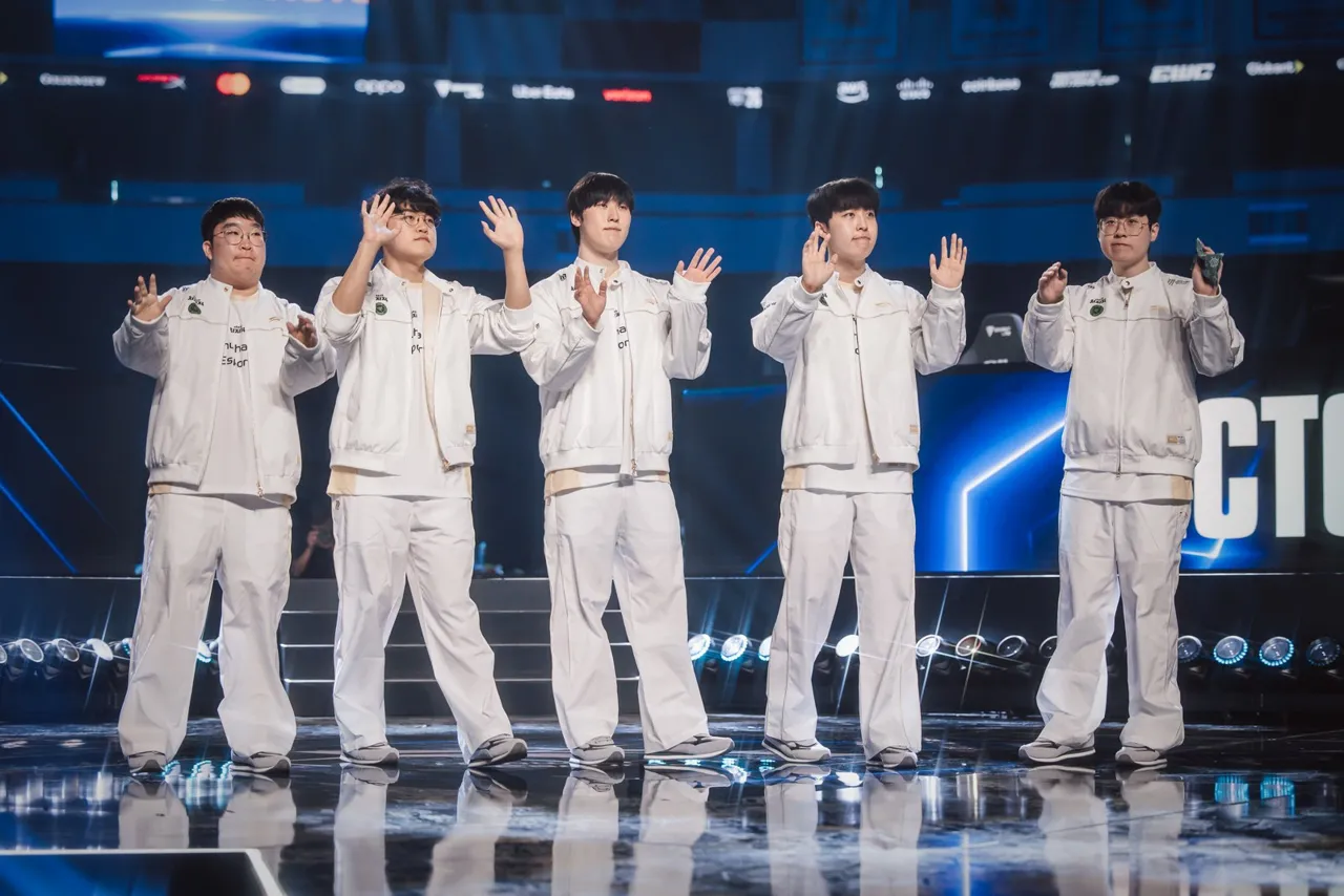 Os cinco jogadores da Hanwha Life, de branco, acenam para o público no palco do Worlds 2026