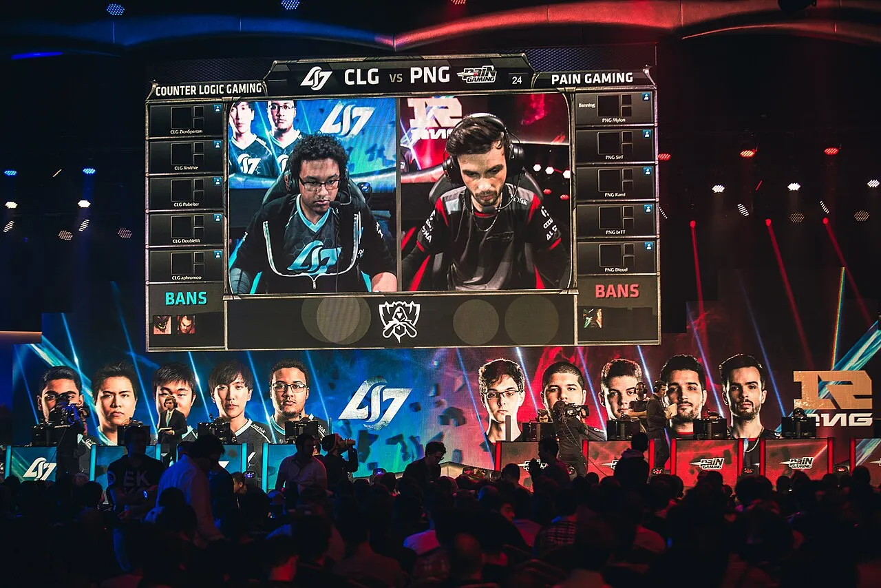 Palco do Mundial de 2015 em Paris com os jogadores da CLG e da paiN Gaming alinhados sob o telão da partida