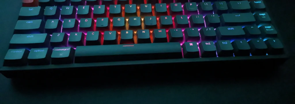 Teclado mecânico com iluminação RGB numa mesa escura, onde se digitam os comandos de console do CS2